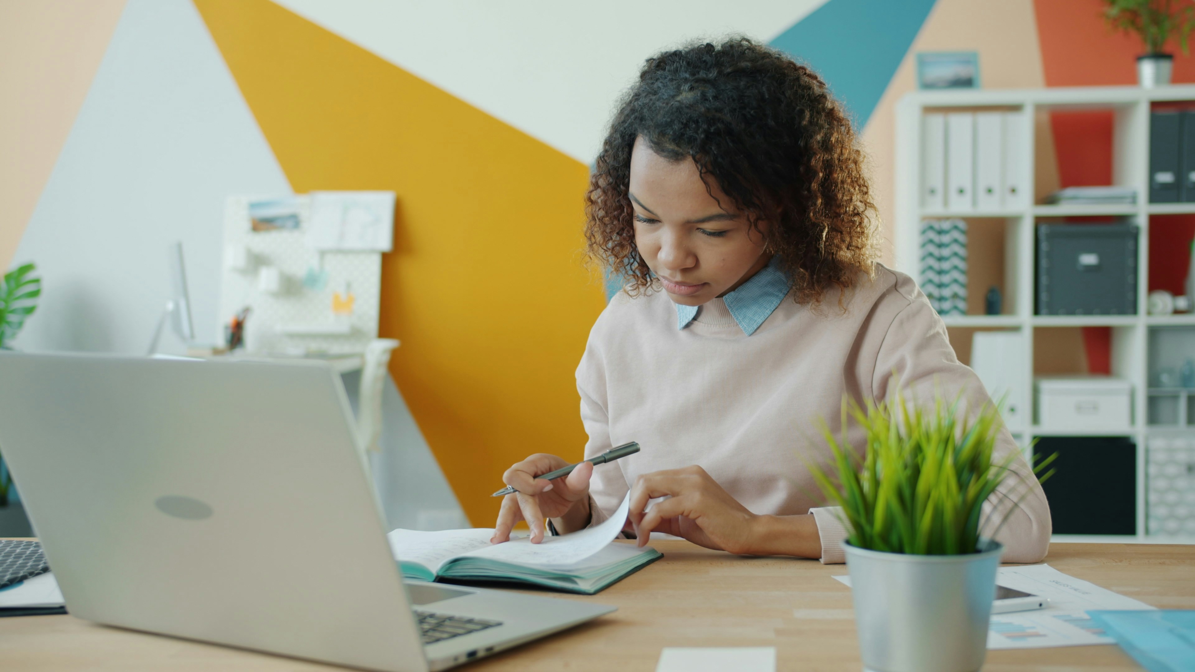 Professional reviewing laptop and notes 